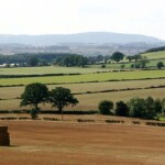 Beautiful rural landscape with fields, trees, and distant hills in en_GB.