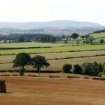 Beautiful rural landscape with fields, trees, and distant hills in en_GB.